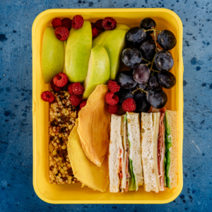 sandwich, fruit and granola in a lunch container
