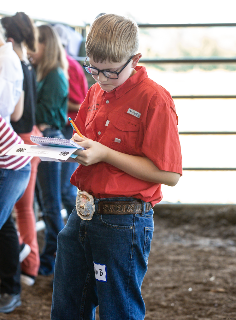 A teenager takes notes on a small notepad.