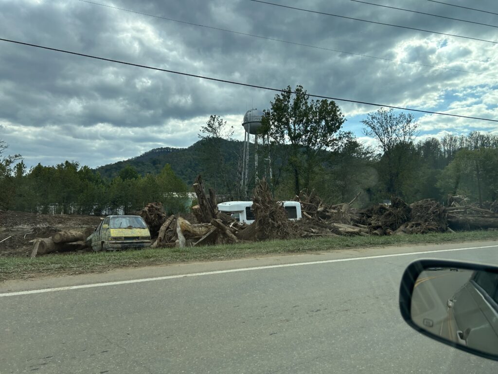 Hurricane Helene damage with trees fallen on side of road in Buncombe County.