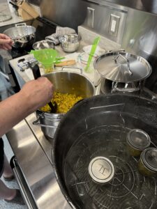Filling jars with relish and home canning in water bath canner