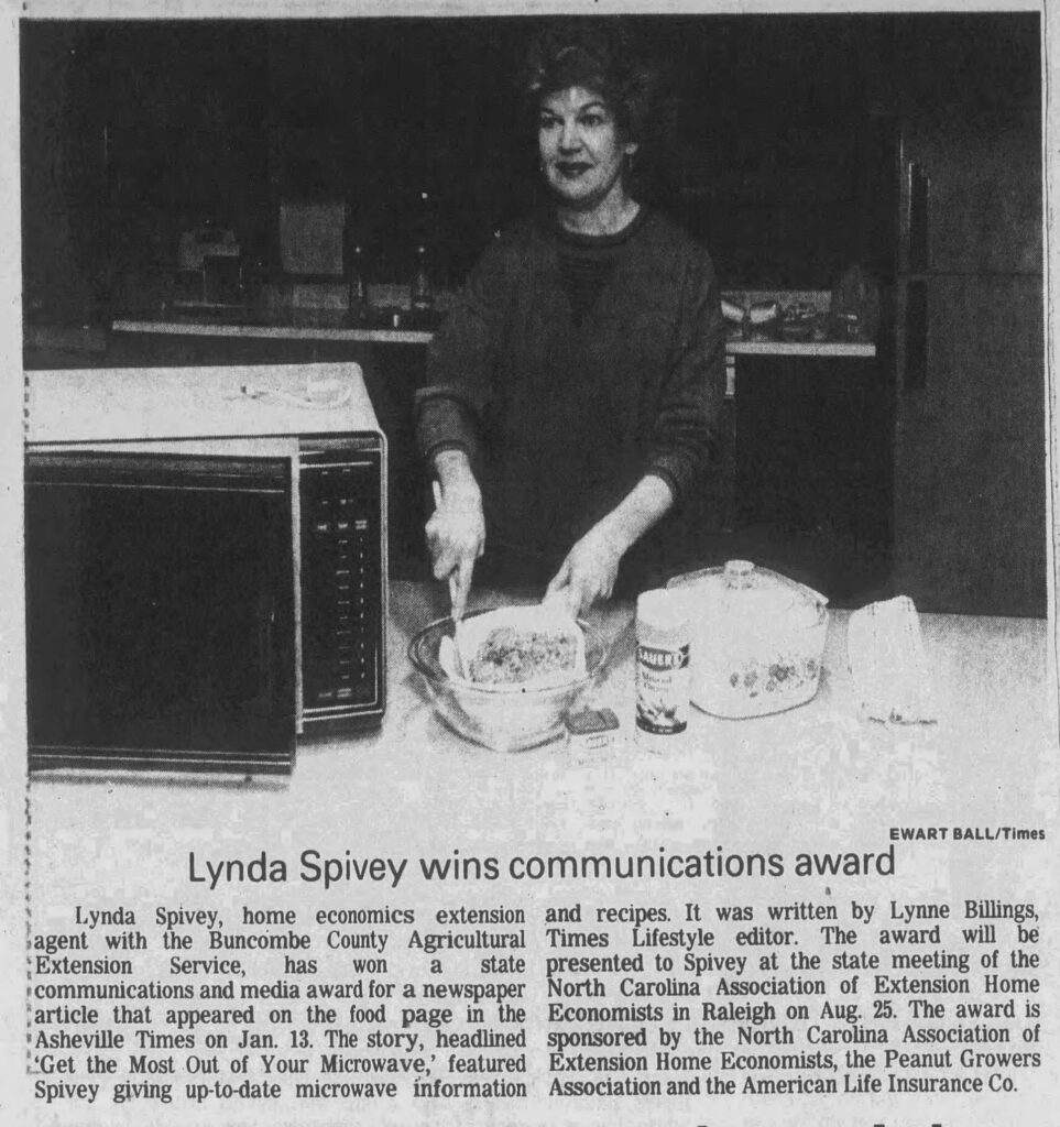 Black and white newspaper photo from 1988 of Lynda Spivey, Buncombe County Cooperative Extension Home Economist, cooking a meal using the microwave. 